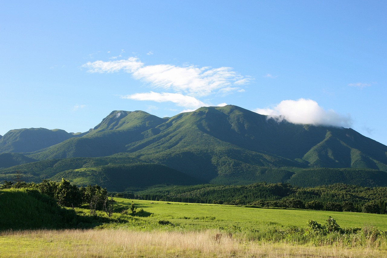 青空に悠然とした山々と草原の風景