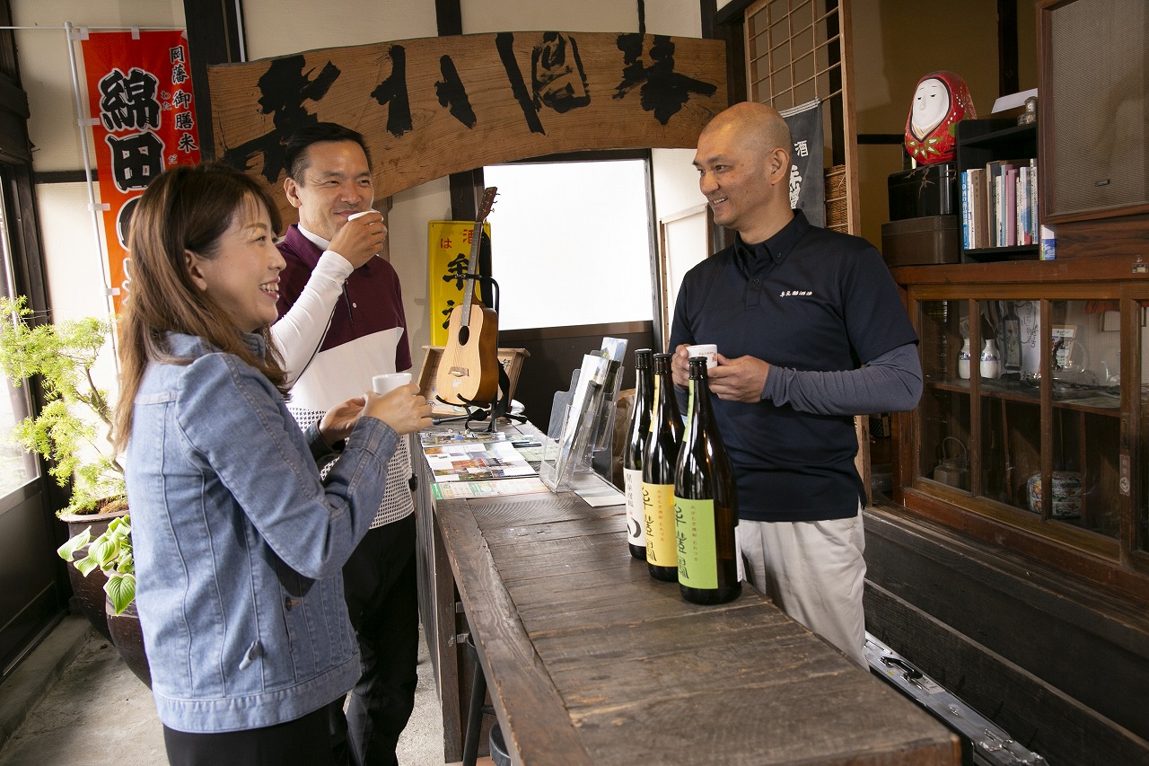 酒蔵で立ち飲みする客と店主